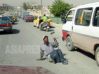 検問で渋滞の市内の道路では、足を失った男性が物乞いをする姿があった。（撮影　玉本英子）