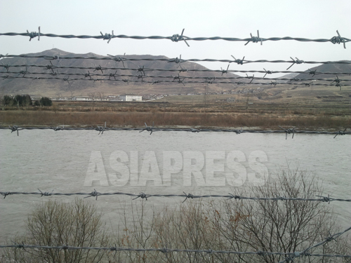 （参考写真）豆満江の向こうに北朝鮮の咸鏡北道穏城（オンソン）郡を臨む。中国当局は豆満江の中国側沿岸に広範囲にわたって鉄条網を設置し、北朝鮮からの脱北や密輸行為をけん制している。2012年11月朴永民（パク･ヨンミン）撮影（アジアプレス）