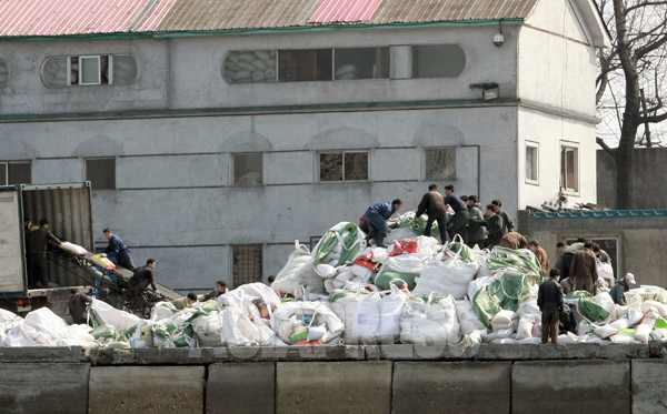 （参考写真）中国から輸入された肥料や食糧などの物資を積み込む北朝鮮の人々。平安北道新義州（シニジュ）市を中国側から撮影した。2012年 3月 南正学（ナム・ジョンハク）撮影（アジアプレス）