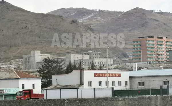 「先軍朝鮮の太陽金正恩将軍万歳」のスローガンが掲げられた建物は軍事関連の施設。赤い星マークがその目印だ。（写真：アジアプレス）