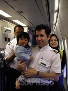 今はなき東京―テヘラン直行便の機内にて、客室乗務員に抱きかかえられる息子。この後、おもちゃやジュースなどを頂く。（撮影筆者／2008年）
