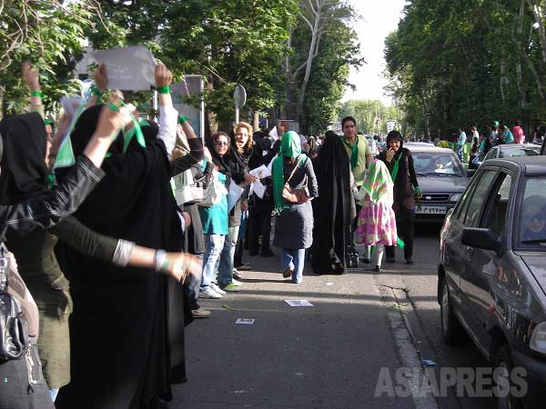 テヘランのメインストリートの一つヴァリアスル通りを埋め尽くすムーサヴィ支持者の街頭運動。支持者らはムーサヴィー派のシンボルカラー、緑を身に着けている。選挙後の騒乱では、彼らは自らを「緑戦線」と呼ぶことになる（2009年6月・撮影筆者）