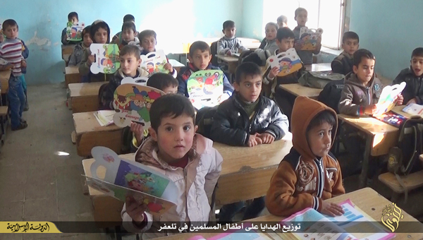 ISは教育行政も行っている。小学校はISの統治が始まって以降はコーランをもとにしたイスラム関係の授業が中心となった。写真はニナワの小学校の児童に文房具を配布する様子。IS映像より
