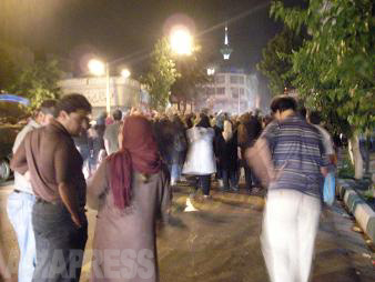 "2009年のイラン大統領選挙では、開票結果に疑念を抱く改革派支持の市民たちが抗議運動を開始。治安部隊との大規模な衝突だけでなく、小さな集団が夜な夜な町を静かに練り歩く草の根の抗議運動が展開した。写真は拳を上げながら筆者自宅前を通過する100人ほどの市民（2009/6月・テヘラン）FONT