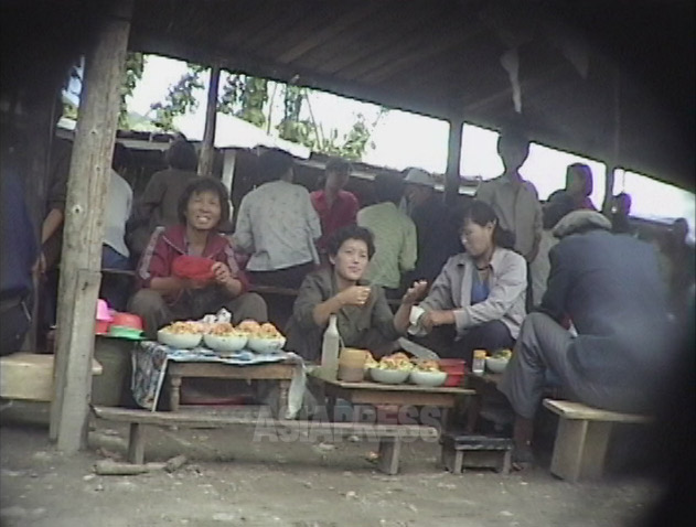 闇市場の中の食べ物屋台。女性たちが唐辛子粉をかけたソバを売っている。1999年9月咸鏡北道茂山(ムサン)郡にて撮影キム・ホン(アジアプレス)