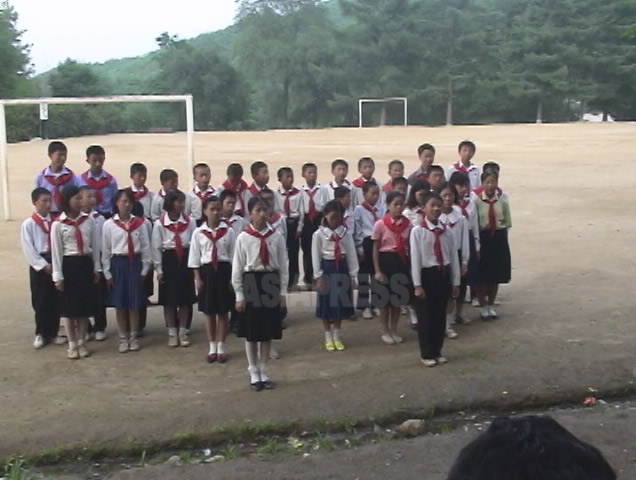 咸鏡北道の少年団の幹部たちを対象にした夏期キャンプで歌を披露している様子。赤いマフラーが少年団の証だ。（2006年7月　リ・ジュン撮影）