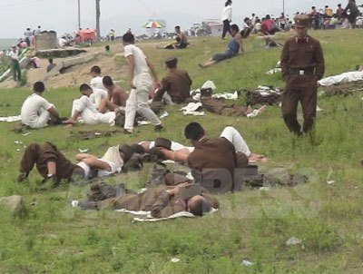 ミサイル発射直後の2006年8月15日の光復節。休憩中の軍人たちが河原で元気なく寝そべっている。「栄養不足で力が入らないせいだ」と撮影者のリ・ジュンは言う。