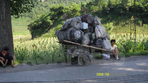 酒や水を入れるポリ容器を運んできた女性が一休みしている。