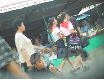 トンバル（厚底靴）にハイソックス姿で市場を闊歩する女子中学生。（2007年8月平壌市　リ・ジュン撮影）
