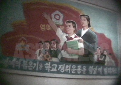 「全員で〈栄誉の赤い旗〉学校の争取運動を力いっぱい繰り広げよう」。中学校の壁に掲げられたスローガン。（2006年4月某中学校にて　ペク・ヒャン撮影）