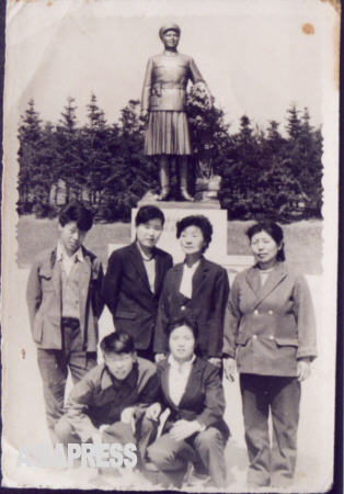 キルスの祖母の住んでいた咸鏡北道会寧（フェリョン）市は、金日成の最初の妻・金正淑（キム・ジョンスク、金正日の実母）ゆかりの地。金正淑の銅像の前での記念写真。キルスの伯父に当たるデハン氏（前列左）と祖母のチュノクさん（後列右から2番目）が中国に脱出した。