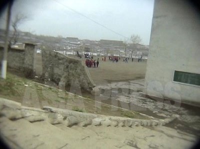 教室に向かう前にリ・ジュンのカメラが捉えた校庭と校舎。石畳や階段、壁には崩れやひび割れが目立つ。コンクリートの質が悪い上、修理に手が回らないためだという。（2006年6月　リ・ジュン撮影）