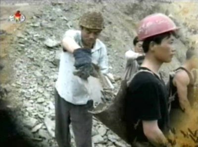 「6.18突撃隊」が両江道の三水（サムス）発電所建設現場で働く様子が、2004年9月に朝鮮中央テレビで放映された。写真はそれをキャプチャーしたもの。危険な工事現場であるにもかかわらず、軽装でヘルメットを被っていない人も多い。番組では、重機も全く不足しているため人海戦術で成果を上げていることを自賛していた。
