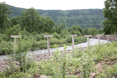鴨緑江上流に張られた鉄条網は、森林地帯にはえらく不釣り合いだ。2010年7月　李鎮洙撮影　©アジアプレス