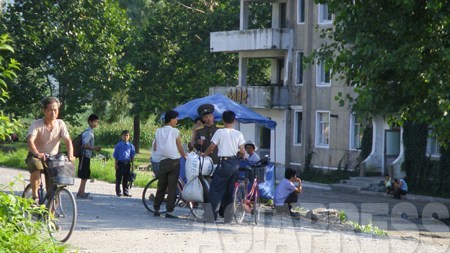 北朝鮮朝鮮労働党の機関紙である労働新聞によれば、現在、各地域の代表者が続々と平壌に集結しているという。写真は平壌市郊外で身分証を確認する保安員（警察官）。2008年9月　張正吉撮影　©アジアプレス