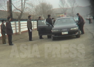 労働鍛錬隊の門前につけた高級車に収容者数人が乗せられていくところ。車は検察幹部のもので、私的な用事に使役させるのではないか、と撮影者のリ・ジュンは言う。（2006年4月咸鏡北道　リ・ジュン撮影）