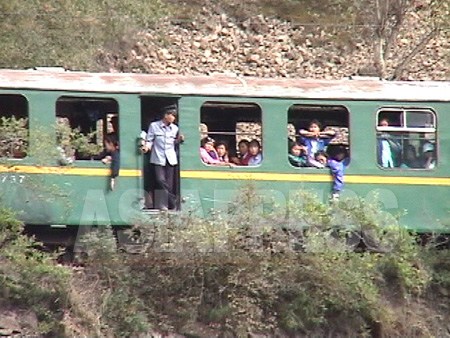両江道恵山市近郊を走る北朝鮮の鉄道列車。窓ガラスが無い。90年代後半の「苦難の行軍」と呼ばれ多数の餓死者が出た経済難の時期、人々がぎゅうぎゅう詰めの列車に窓から乗り込んだ名残だ。2002年8月　中国側から石丸次郎撮影（アジアプレス）