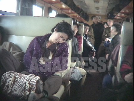 北朝鮮の鉄道列車内の様子。奥に金日成－金正日の肖像画が見える。2005年6月　李準（リ・ジュン）撮影（アジアプレス）