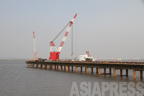 川に橋のようにせり出した建造物は、作業船に資材を積み出すための埠頭（停泊地）の役割を果たすものと思われる。2011年5月　アジアプレス取材班撮影 (C)アジアプレス