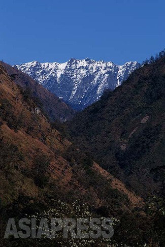 タストゥー村から北に目をやると、山と山の間に、真っ白な雪を頂いたダンディー山を垣間見る。
