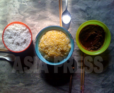 庶民の食卓を再現してもらった。トウモロコシ飯と、おかずは野菜を味噌であえたもの（右）と、塩（左）ぐらいだという。（2011年3月両江道恵山市　チェ・ギョンオク撮影）
