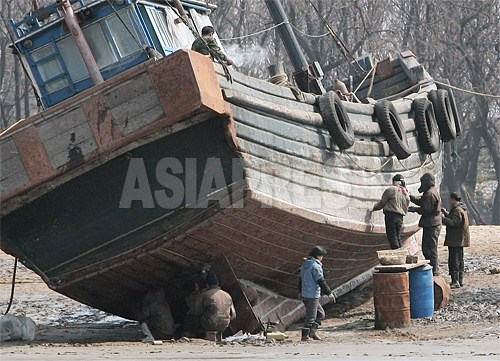 漁師と思われる住民たちが、船を手入れしている。