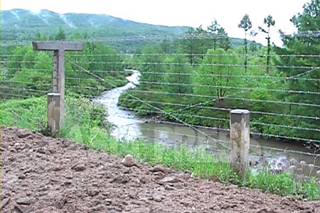 【資料写真】豆満江の最上流地域に設置された鉄条網。この付近の川幅は数メートルに過ぎない。2009年6月石丸次郎撮影