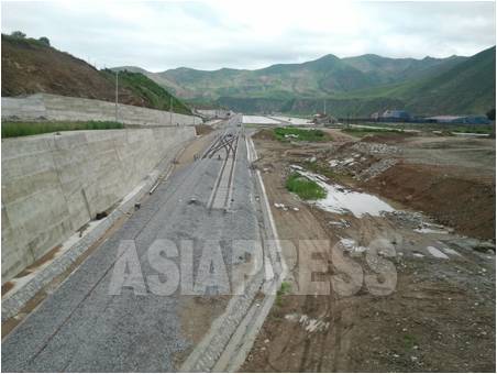 中国の吉林省・延辺朝鮮族自治州に建設されている「和坪鉄道」。奥の白い場所が南坪鎮の駅舎。背後の山並みは北朝鮮。今月5日、パク・ヨンミン撮影（アジアプレス）