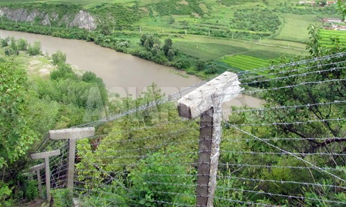 豆満江を挟んで、咸鏡北道会寧（フェリョン）市を臨む高台に新たに増設された鉄条網。傾斜が急であるにも関わらず隙間なく設置されている。2012年9月　ナム・ジョンハク撮影（アジアプレス）