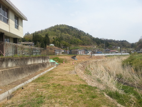 小国小学校の校庭の裏側には堤と小川。高い放射線量を記録した（2013年5月　伊達市小国地区）