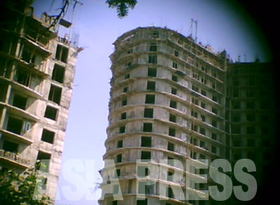 平壌中心部で建設されていた20階を超える高層アパート。各階を手積みする北朝鮮独特の「ブロック工法」で建てられている。各階の窓枠の位置も大きさもまちまちで歪んでいる。2011年8月平壌市大同江区域 撮影：具光鎬（ク・グァンホ）記者（アジアプレス）