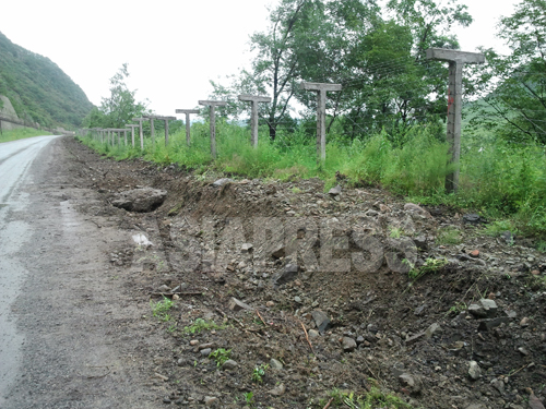 豆満江沿いを走る道路に設置された鉄条網。豆満江下流の琿春市にて7月31日撮影。写真パク･ヨンミン／アジアプレス