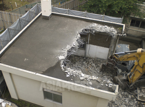 2011年5月、神奈川県綾瀬市の綾瀬小学校旧校舎解体工事で起こったアスベスト飛散事故の様子。2本の煙突に高濃度のアスベストが使用されていたが、対策なしで解体された。解体時は通常どおり授業が行われており、生徒らの曝露が懸念されている（写真：綾瀬市提供）
