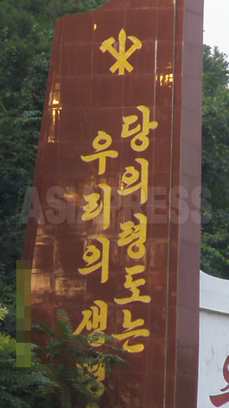 街のいたるところに掲げられた朝鮮労働党のスローガン。「党の領導（指導）はわれわれの生命！」とある。2008年9月 撮影：張正吉（チャン・ジョンギル）