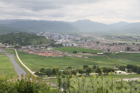 （参考写真）咸鏡北道会寧（フェリョン）市。間を流れる川は豆満江。中国との国境近くに住む北朝鮮住民とは、中国キャリアの携帯電話によって通話が可能である。2010年6月中国側より撮影（アジアプレス）