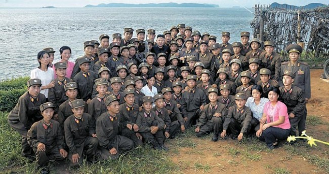 韓国に接する「西南戦線」の最前線部隊の兵士たち。12年8月に現地を訪れた金正恩氏を囲んで記念撮影している。よく見るとほとんどの兵士が痩せこけている。写真の補正を頻繁に行う北朝鮮の官営メディアも、兵士の栄養状態までは隠せない。労働新聞より引用。