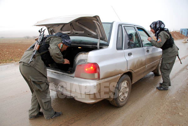 車の中を丹念にチェックする人民防衛隊の女性民兵。昨年11月にアイン・アル・アラブ市内で大規模な自動車爆弾攻撃が起き、多数の市民が死傷した。その後、治安警備が一層強化された。（シリア北西部・アレッポ県：1月撮影・玉本英子）