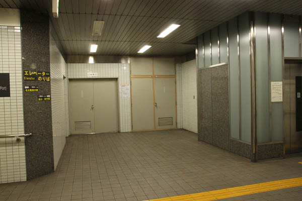 高濃度のアスベストが漏えいした名古屋市営地下鉄・六番町駅の機械室前。中央奥右手の目張りがしてあるところが機械室。閉鎖は右手のエレベーター乗り場まで。とくに漏えいを防止する措置はなかった（2013年12月撮影・井部正之）