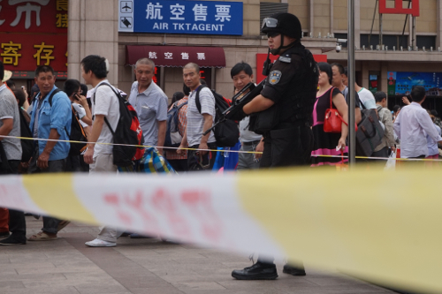 自動小銃で警戒にあたる警察官。2014年7月9日 北京駅。 撮影 宮崎紀秀