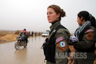 イスラム武装勢力のISIS（イラク・シリア・イスラム国＝現「イスラム国」）の支配地域につながる道の検問所では、クルドの人民防衛隊の女性戦闘員が厳しい取締りをおこなっていた。 （アレッポ北部にて2014年1月撮影・玉本英子）
