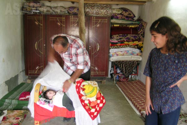 ゆりかごにこどもを寝かすヤズディ一家の父親。本来はヤズディでは男児は割礼はしない、とされるが、割礼をする地域もある。イスラム教にみられるような教義的なものというより、地域の慣習的なものという。(シェハン・2005年)