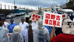 沖縄･キャンプシュワブ前で毎日行われている抗議行動。全面に立つのは民間警備会社の作業員（2014年8月 栗原佳子撮影）