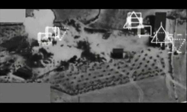 米軍はコバニ周辺のイスラム国拠点に連日、空爆をおこなっているが、イスラム国は猛烈な速度で町への攻勢をかけている。写真は米軍F15戦闘機が9月27日、コバニ近郊でイスラム国の施設に爆撃をおこなった映像。写真左の施設が大きく吹き飛んでいる。中央右の黒い点模様はオリーブ畑と思われる。（米中央軍公表映像から）