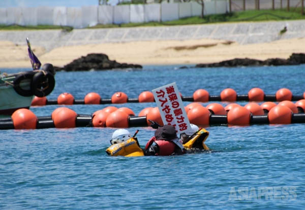 沖縄・辺野古の新基地建設に向けた海底ボーリング調査に対し、カヌーでの抗議活動中に海上保安官に拘束された市民。（撮影：吉田敏浩）