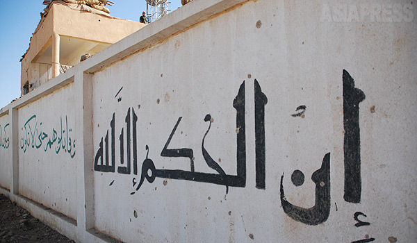 建物の壁にはイスラム国が書いた「アッラーが審判を下す」の文字が残されていた。シリア北東部のたくさんの町や村では、戦闘が続いている。（９月、シリア北東部・玉本英子撮影）