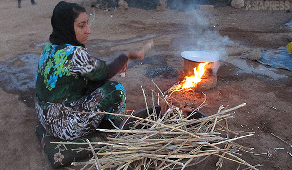 【シリア北東部】 その日の食事を作るだけでも大変だ。ガスやコンロを持っていない人びとは、周辺から木や草を拾い集めてきて、火をおこしていた。（シリア北東部・デレクで ９月・玉本英子撮影）