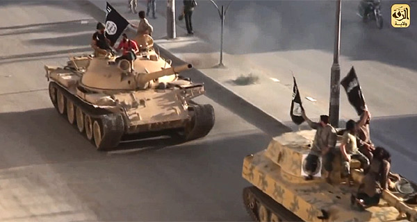 シリア内戦の混乱で台頭したISが2013年にラッカの支配を固めると、独自解釈したイスラム法にもとづいて行政機構を改変し、統治を行うようになった。住民の脱出があいつぎ、人口は減少している。写真はシリア政府軍から奪取した戦車でラッカ市内をパレードする戦闘員ら。（IS映像）
