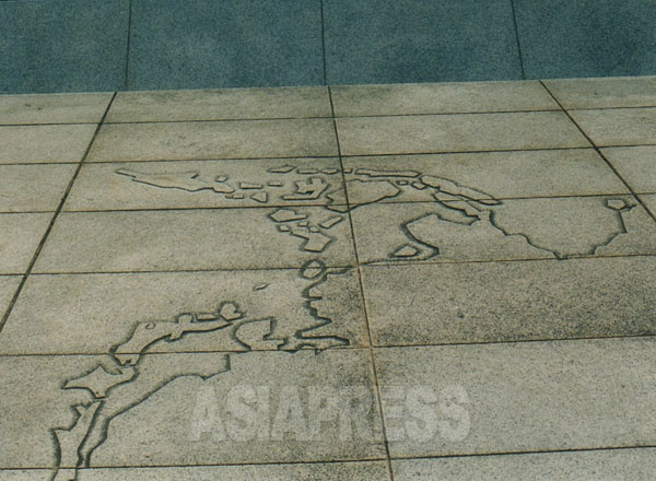 戦没船員の碑の前のレリーフ。戦場となったアジア・太平洋の地図を彫っている。撮影 吉田敏浩