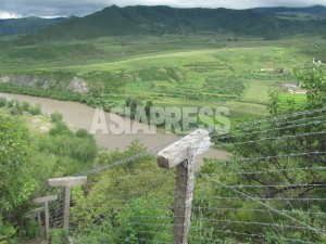 脱北者流入防止のために、豆満江の中国側全域には鉄条網が張られている。2012年8月撮影アジアプレス