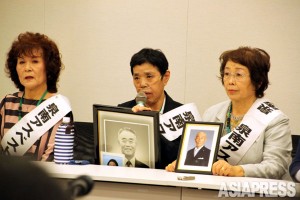 遺影を手に記者会見に臨む原告たち。最高裁判決までに14人が亡くなった